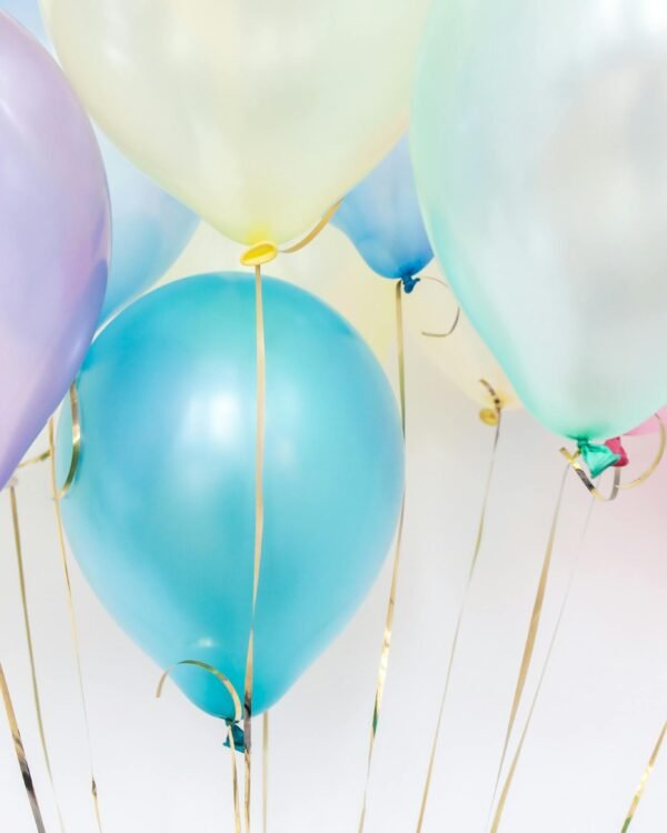 Pastel balloons floating against a neutral background, perfect for festive events.